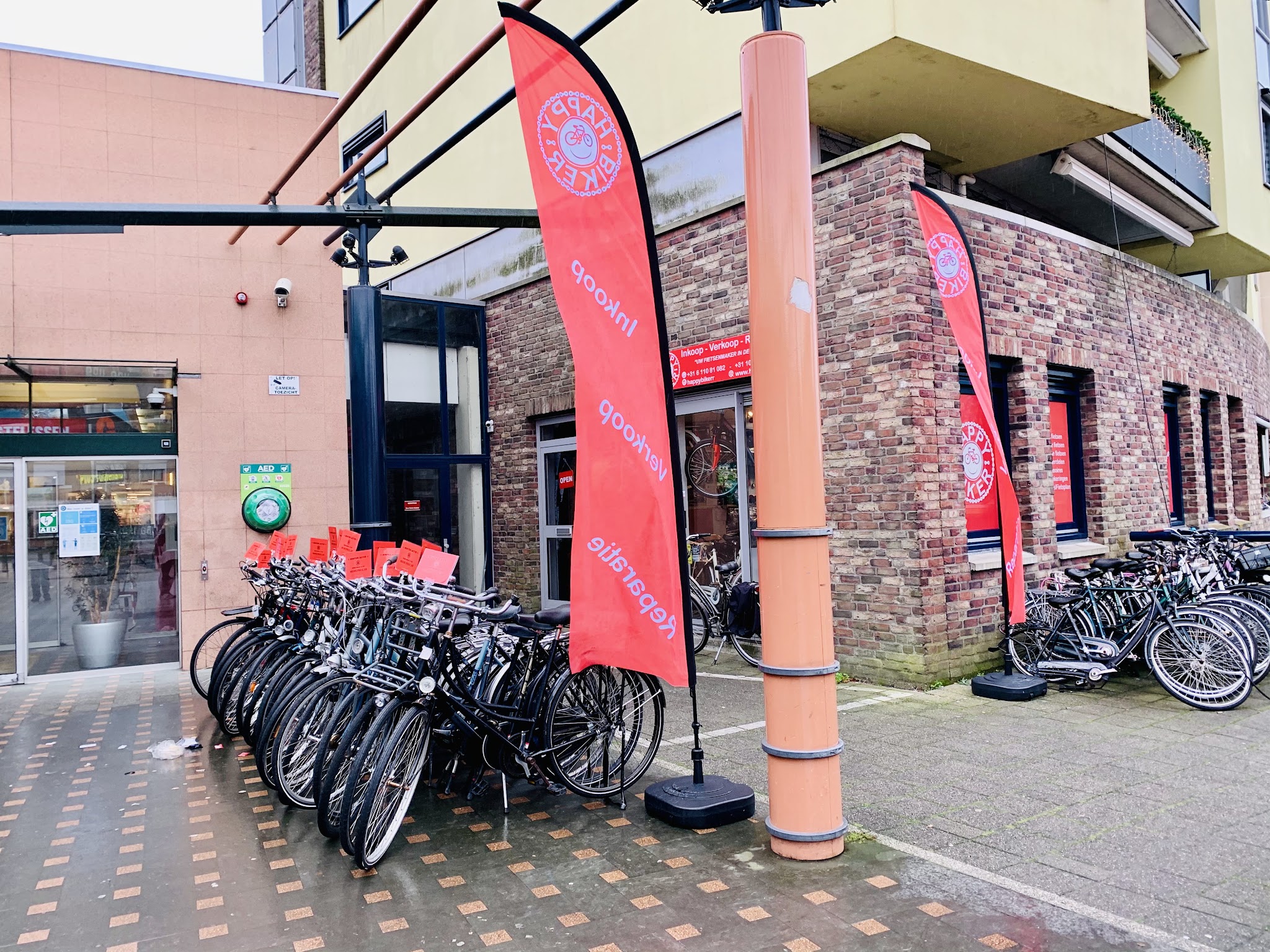 Fietsen met prijskaartjes en twee rode Happy Biker-vlaggen voor de winkel in het winkelcentrum